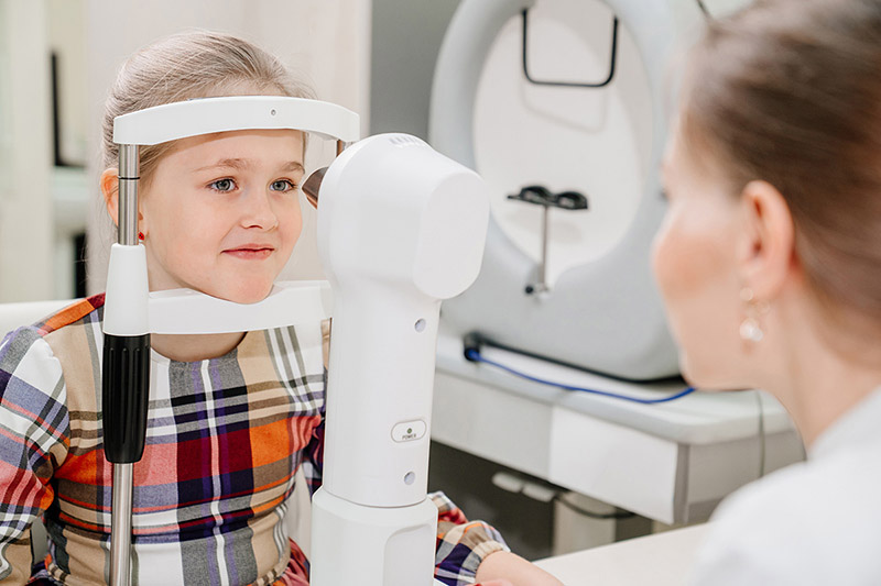 eye slit-lamp exam being performed on a young girl
